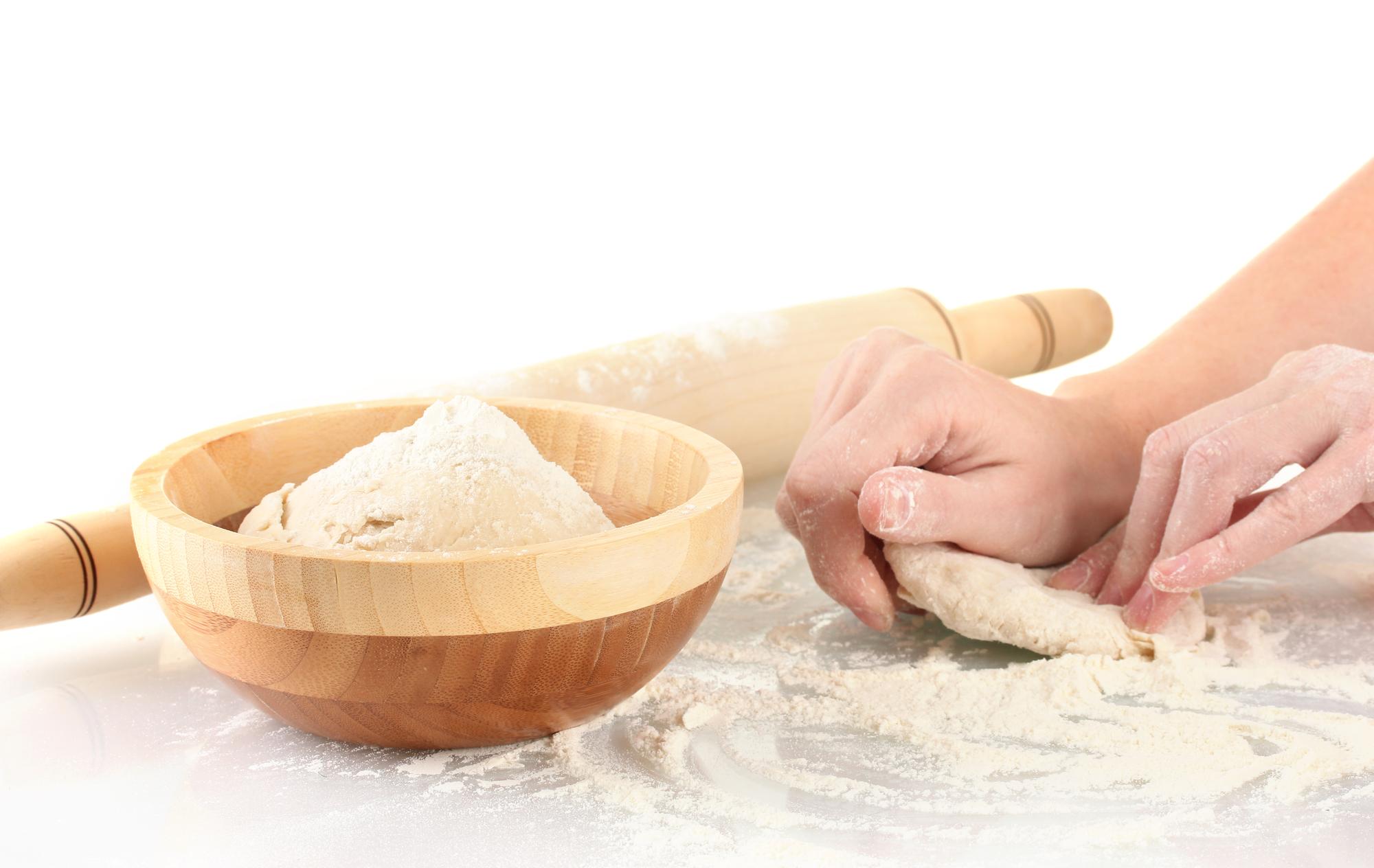 Student kneading dough on a wooden board